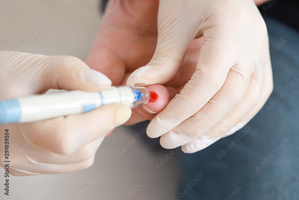 Doctor taking blood sample of diabetic man in clinic, closeup Doctor taking blood sample of diabetic man in clinic, closeup
