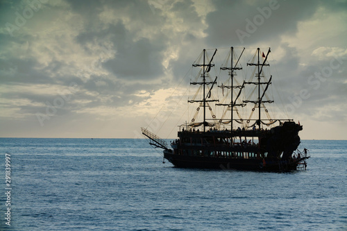 old pirate ship sailing at sea sunset