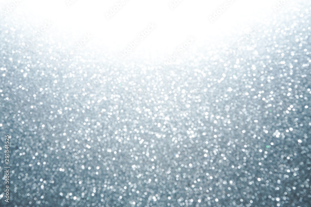 Silver Sparkling Lights Festive background with texture. Abstract Christmas twinkled bright bokeh defocused and Falling stars. Winter Card or invitation