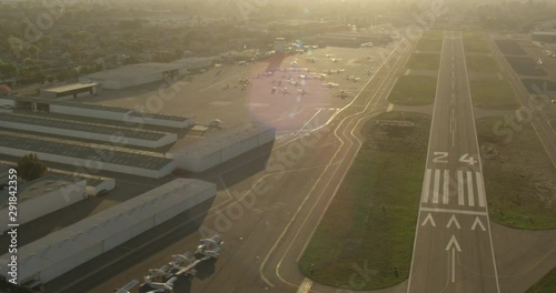 Aerial shot, day, slow helicopter landing approach to runway, drone
