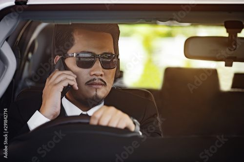 usiness man talking with mobile phone and driving a car © geargodz