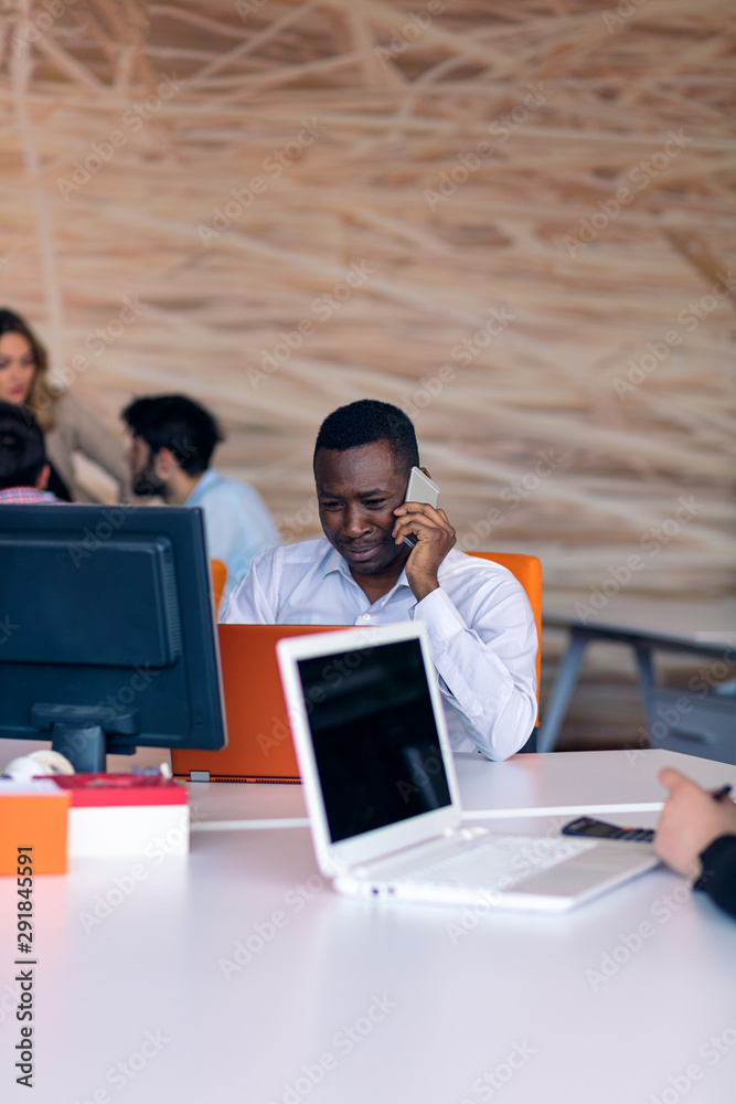 Happy smiling successful African American businessman in in a modern bright startup office indoors Happy smiling successful African American businessman in in a modern bright startup office indoors