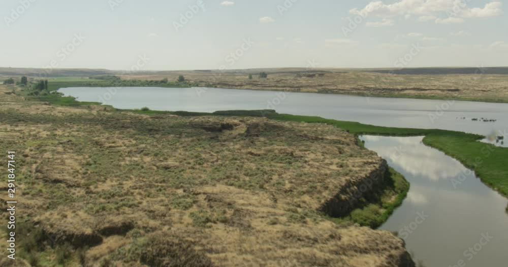 Small lake in the middle of green fields, helicopter aerial, drone Small lake in the middle of green fields, helicopter aerial, drone