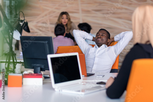 Happy smiling successful African American businessman in in a modern bright startup office indoors