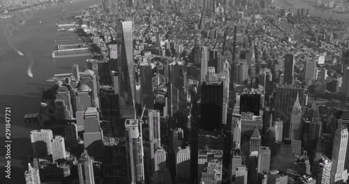 Black and white aerial shot, angled pan over Financial District, end on One World Trade center, drone