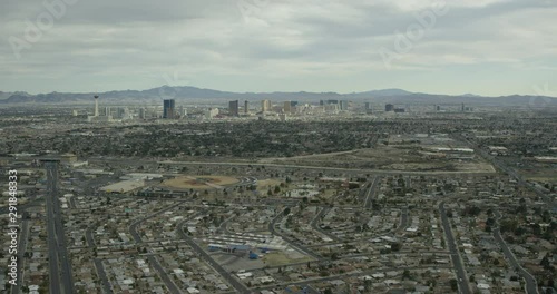 Helicopter aerial shot tracking backward from mountains to urban landscape, drone