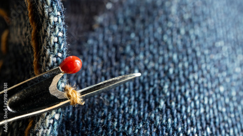 Seam ripper rip out seam on blue jeans fabric