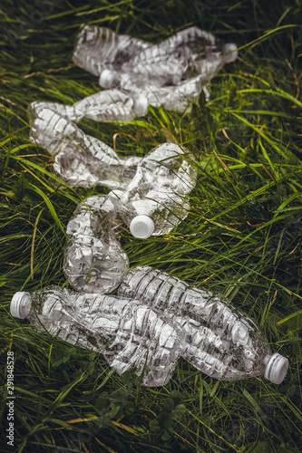 Plastic bottles in the green grass. Problem in the natural environment.