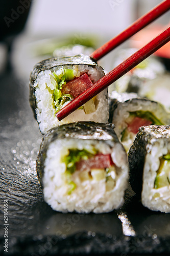 Eating Fresh Vegetarian Sushi Rolls or Veggie Roll with Chopsticks