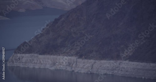 Slow pan over mountains in body of water, helicopter aerial, drone