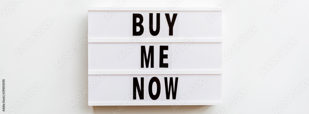 Obraz premium Creative promotion composition buy me now text on lightbox on white background. Horizontal long banner for web design. Flat lay, top view, overhead, mockup, copy space, template