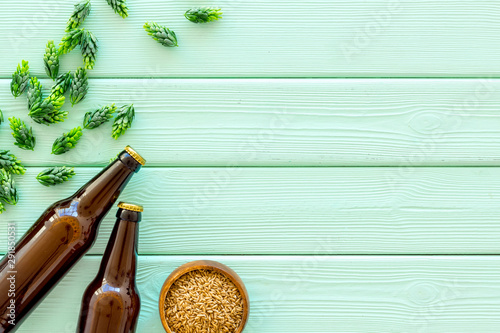 Barley and hop for making beer on green wooden background top view copy space
