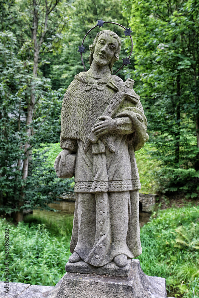 Stony sculpture of Saint man with crucifix