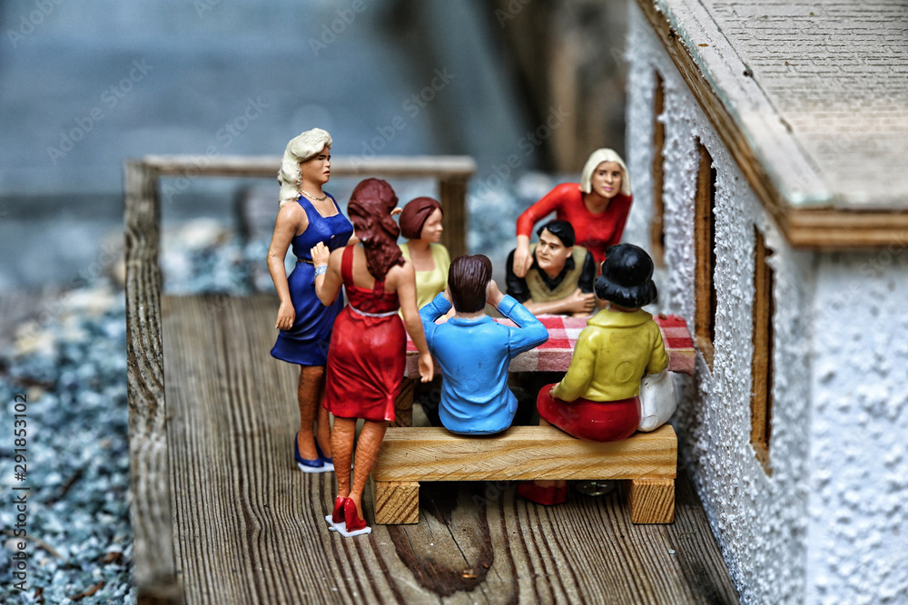 Small model of people group sitting on the wooden terace