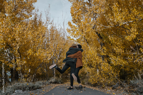 A young couple in love excitingly hugging and spinning together in nature photo