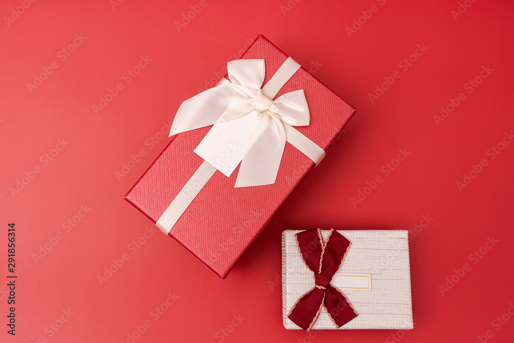 Two gift boxes placed on a red background