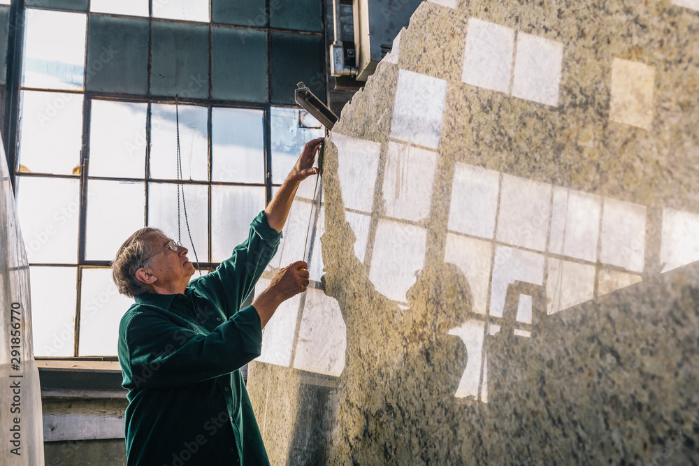 © Raymond Forbes LLC/Stocksy - Senior Worker Measuring Stone Slab © Raymond Forbes LLC/Stocksy - Senior Worker Measuring Stone Slab