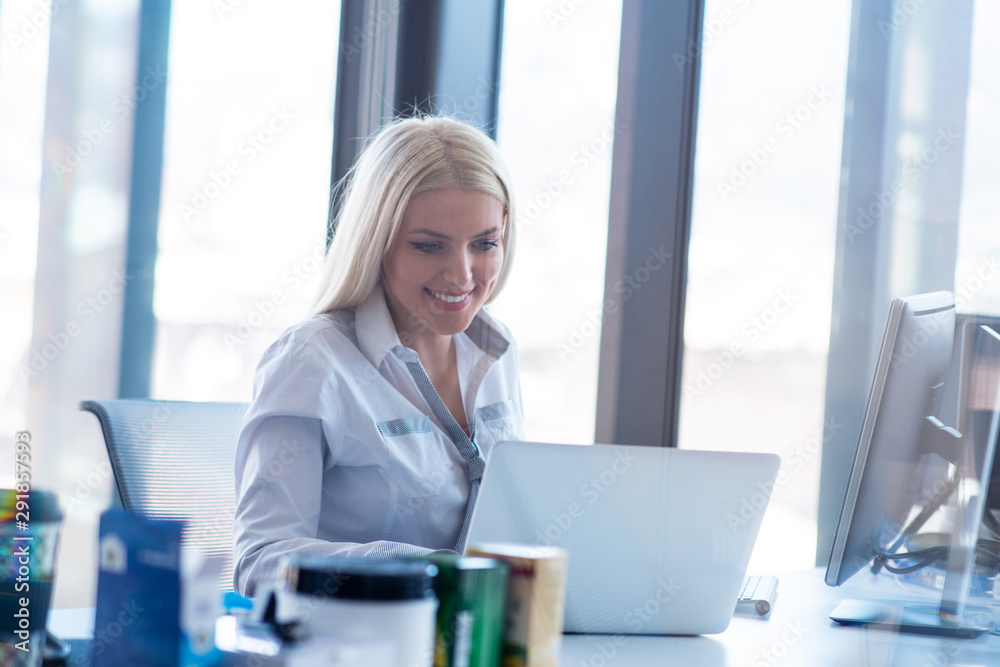 Side view portrait of businesswoman using computer at office desk Side view portrait of businesswoman using computer at office desk
