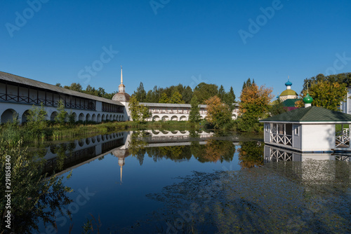 Southwest Сorner tower and the wall of the Tikhvin Assumption (Assumption) Monastery with reflection in the pond. Tikhvin, Russia