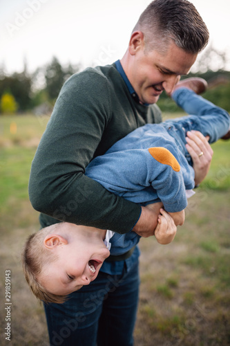 Happy dad playing with son outside. photo