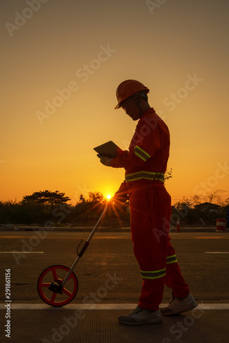 Engineer measuring road distances with a measuring wheel photo