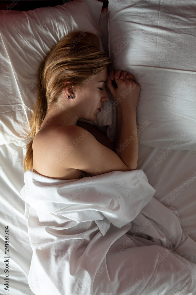 Tattooed young woman sleeping in a bed Tattooed young woman sleeping in a bed