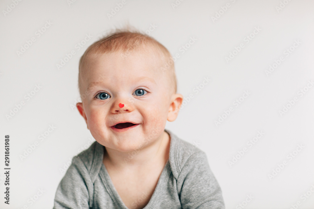 happy baby with a tiny heart sticker on his nose happy baby with a tiny heart sticker on his nose