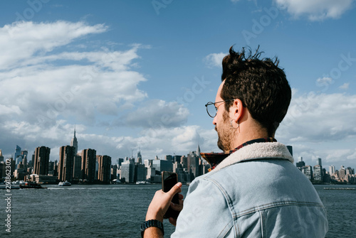 young and attractive man enjoys the views of new york from a boat photo