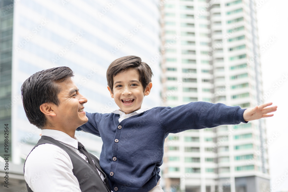Father carries son playing aviator air plane imagination dreaming of being a pilot future on business district urban, Dad and Son happy family concept Father carries son playing aviator air plane imagination dreaming of being a pilot future on business district urban, Dad and Son happy family concept