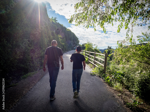 Father and son walking together from behind on Snake River Rim Trail near Shoshone Falls Park, Twin Falls, Idaho, USA