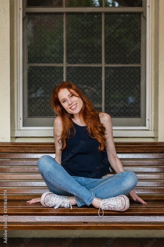 redhead woman sitting on bench redhead woman sitting on bench