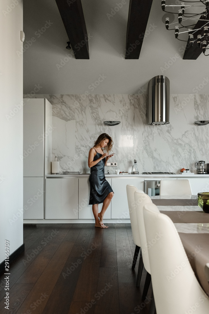 Tender woman using phone in kitchen Tender woman using phone in kitchen