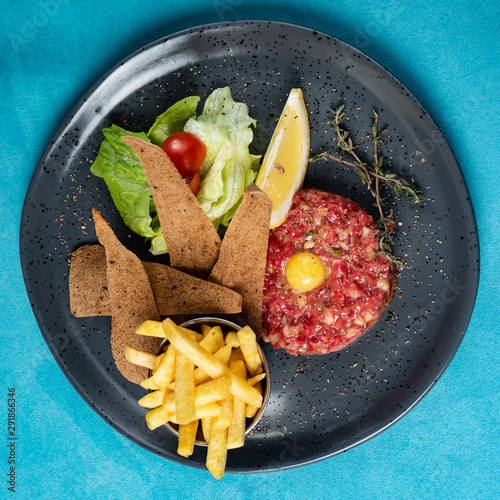 Beef tartare with egg yolk and french fries photo