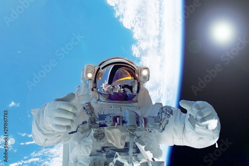 Fototapeta Naklejka Na Ścianę i Meble -  Astronaut in space against the background of the earth. Elements of this image were furnished by NASA