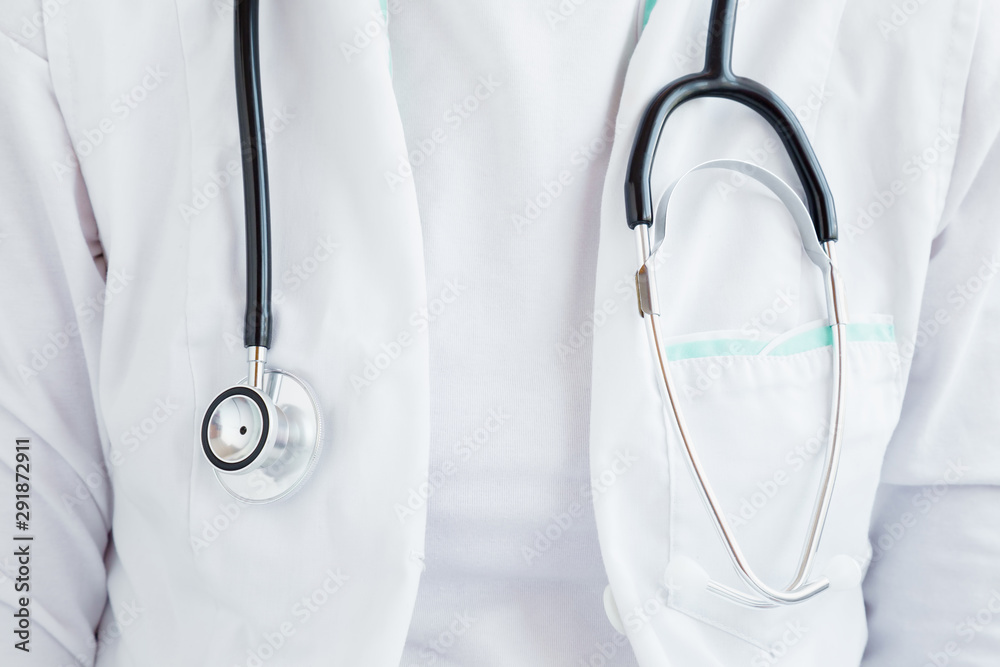 Doctor in white uniform with stethoscope. Tool for heartbeat and noise of lungs listening. Healthcare concept. Front view. Closeup.