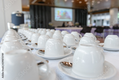 Group of many empty cups with spoons for service coffee or tea in seminar event or meeting room