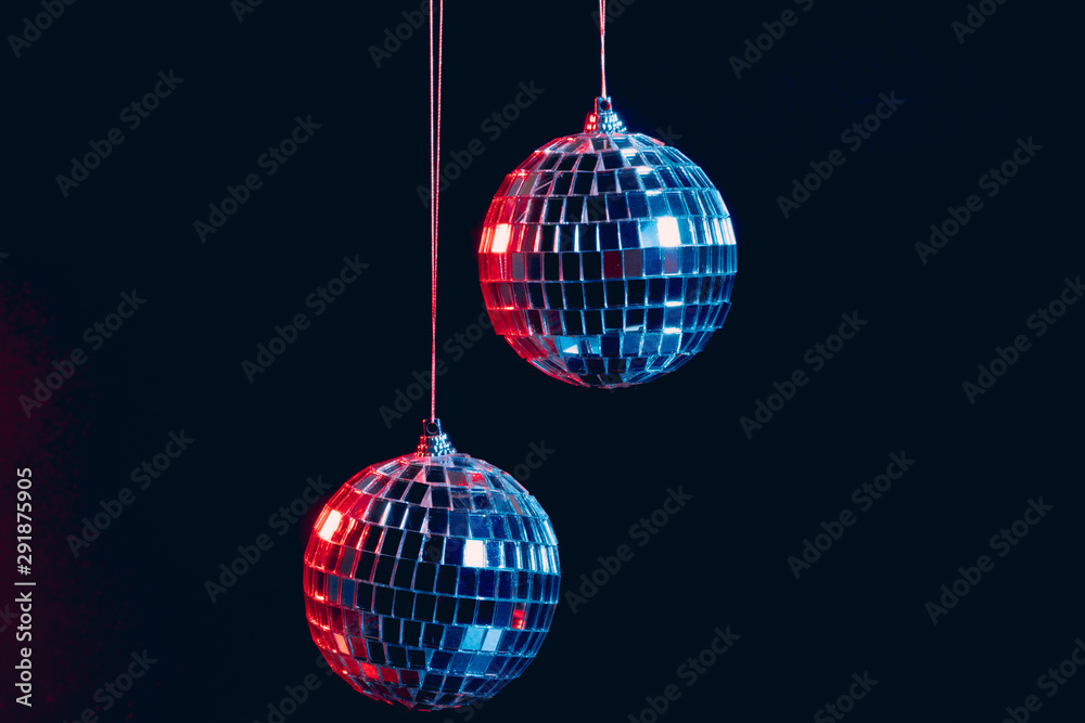 Fototapeta premium Sparkling disco balls hanging in the air against black background