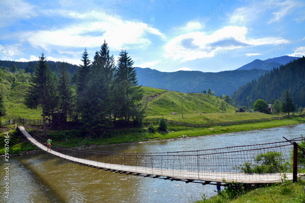 Fototapeta premium a bridge suspended over a mountain river