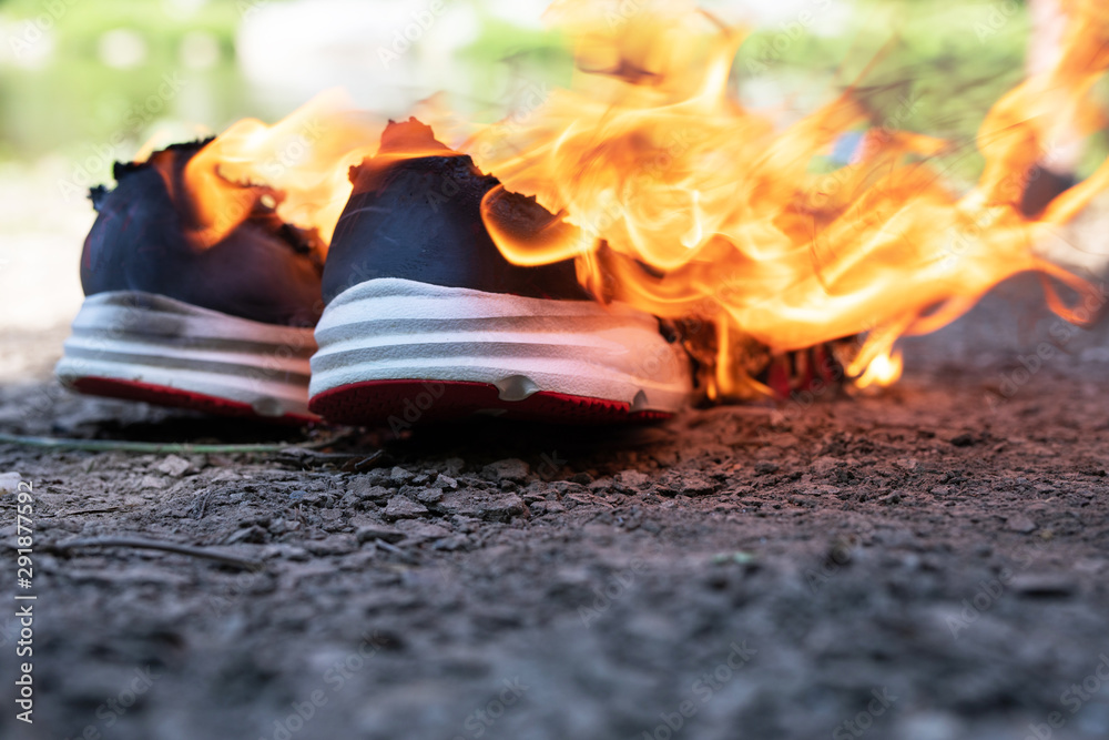 Foto Stock Burning sports shoes. Sneakers or gym shoes on fire stand on the  ground. .athlete burned out in training. burnout from physical exertion,  training | Adobe Stock