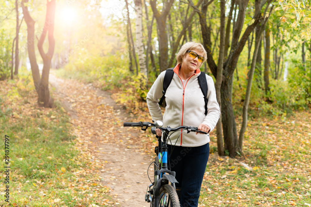 A woman on a Bicycle rides on the road in the Park A woman on a Bicycle rides on the road in the Park