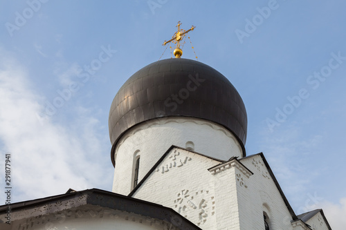 Canvas Print Black dome of an old Orthodox church with a golden cross and part of the facade