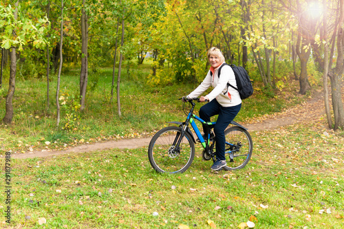 A woman on a Bicycle rides on the road in the city Park