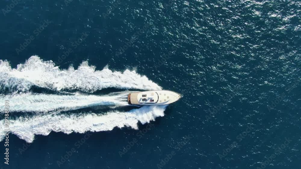 Stunning aerial 4k cinematic high angle drone footage following a powerful luxury high speed yacht rushing through deep blue ocean water near Manly Beach, Sydney, New South Wales, Australia.