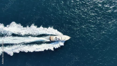 Stunning aerial 4k cinematic high angle drone footage following a powerful luxury high speed yacht rushing through deep blue ocean water near Manly Beach, Sydney, New South Wales, Australia. photo