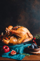 Roasted whole turkey on a table with apple, pumpkin and figs for family Thanksgiving Holiday.