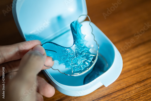 placing retainer for teeth into the plastic box photo