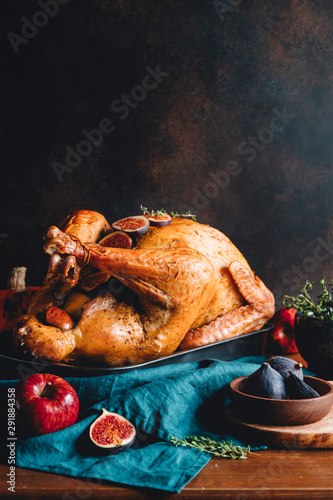 Roasted whole turkey on a table with apple, pumpkin and figs for family Thanksgiving Holiday.