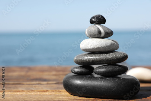 Stack of stones on wooden pier near sea seascape  space for text. Zen concept