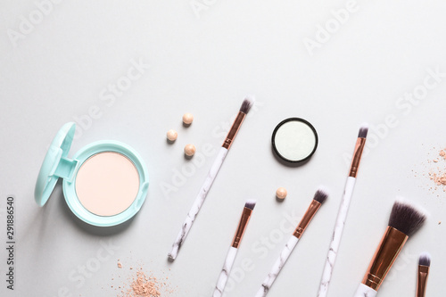 Flat lay composition with makeup brushes on grey background