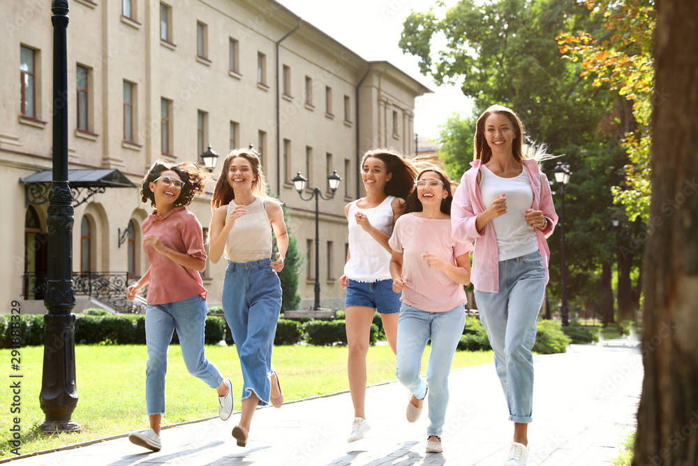 Happy women running outdoors on sunny day. Girl power concept Happy women running outdoors on sunny day. Girl power concept